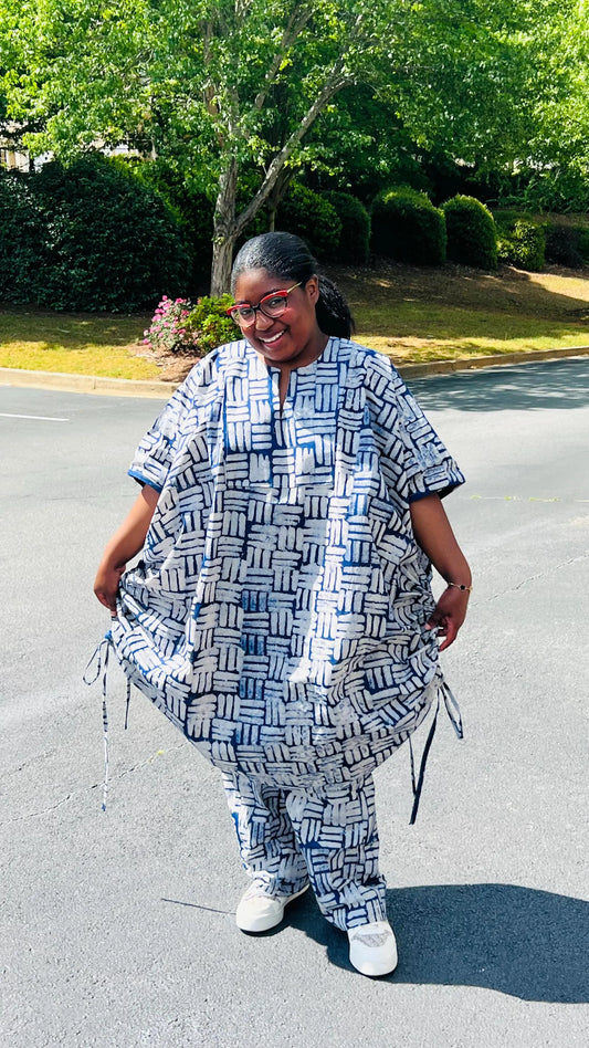 Woman wearing a two-piece African print Adire set with a drawstring Bubu top and matching baggy pants, standing outdoors.